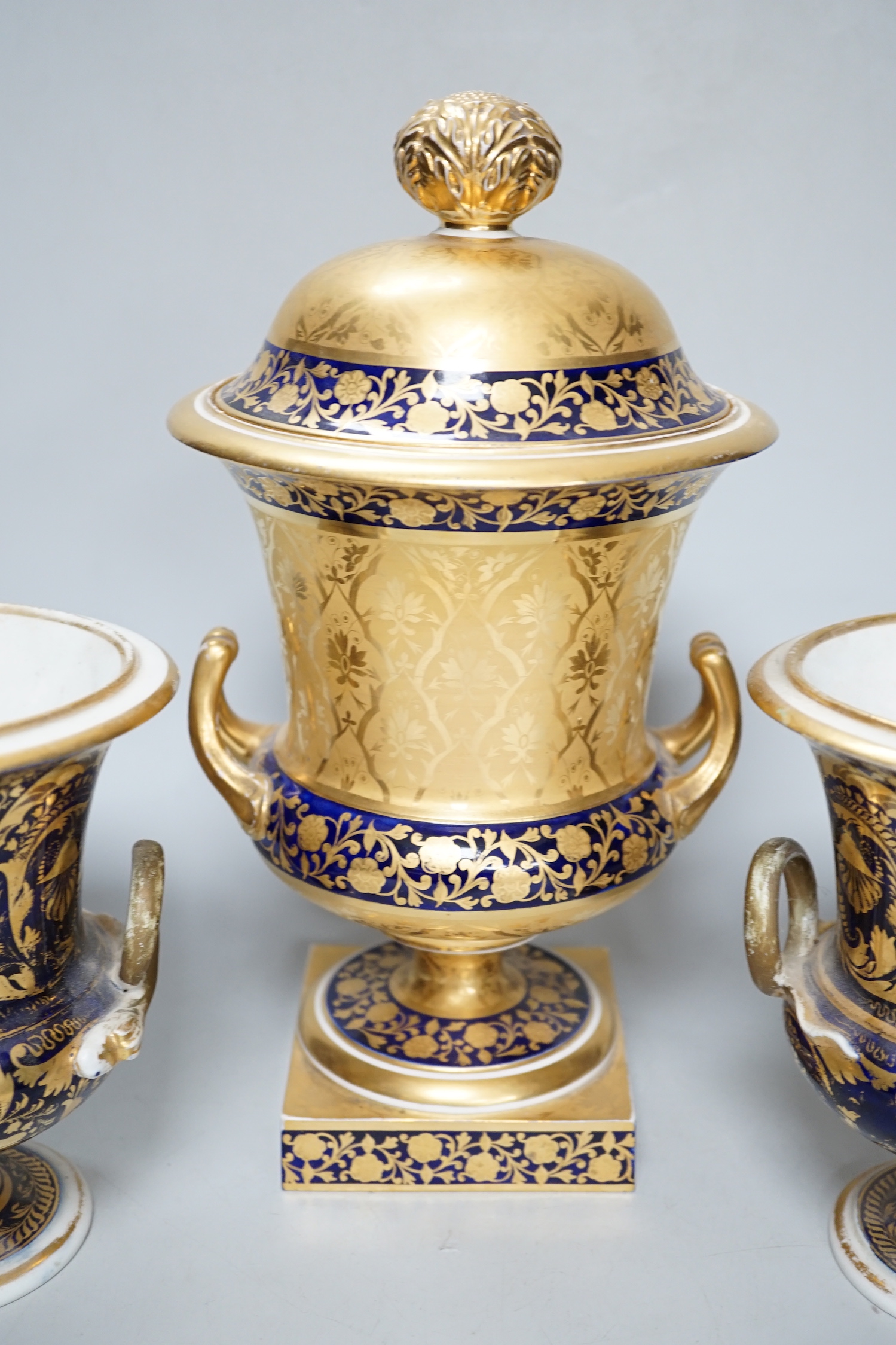 A pair of Derby flower basket painted urns, c.1810, and a larger Derby urn and cover, first quarter 19th century, latter 30cm